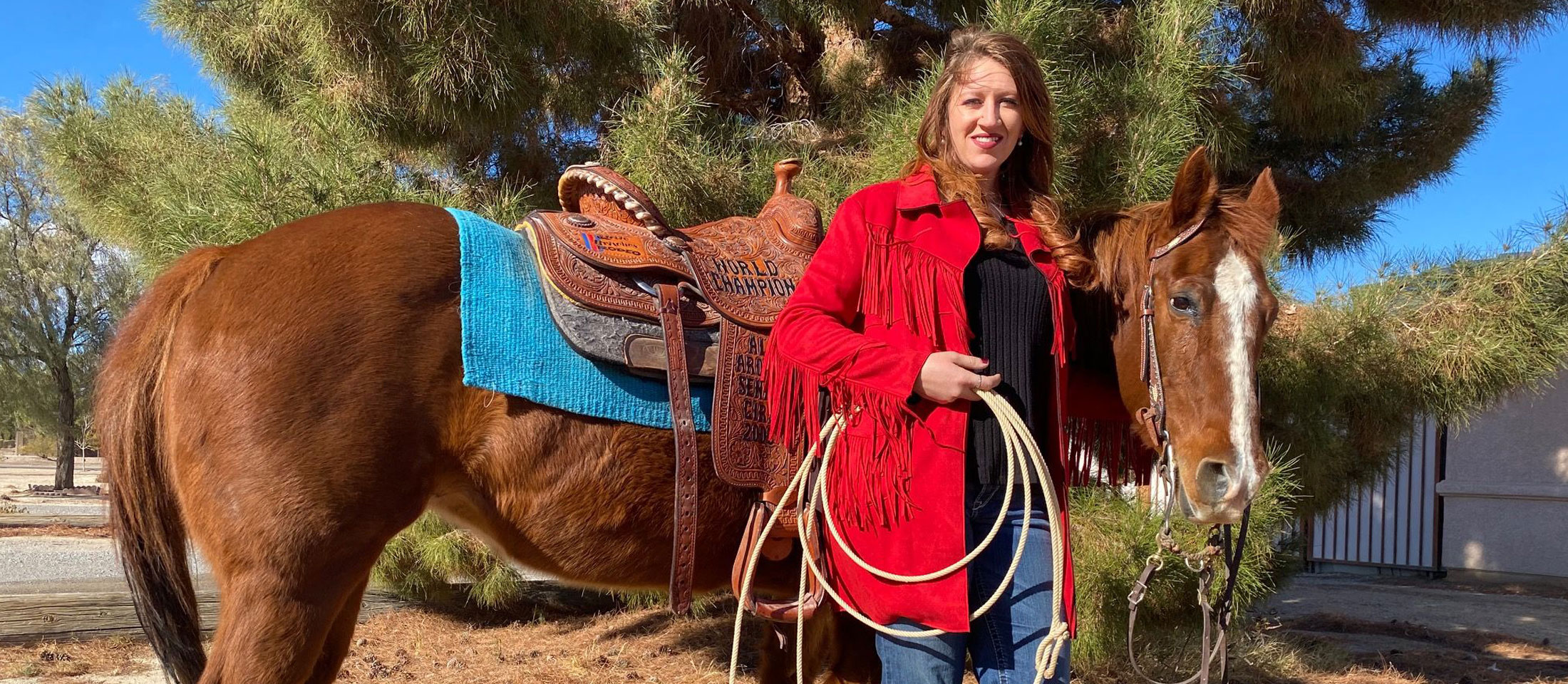 Kaylin Leas Standing next to a horse.